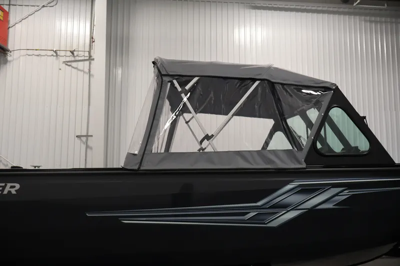 Slide: The Image of 2026 Crestliner 2050 Commander boat with canopy in a warehouse setting. - 42