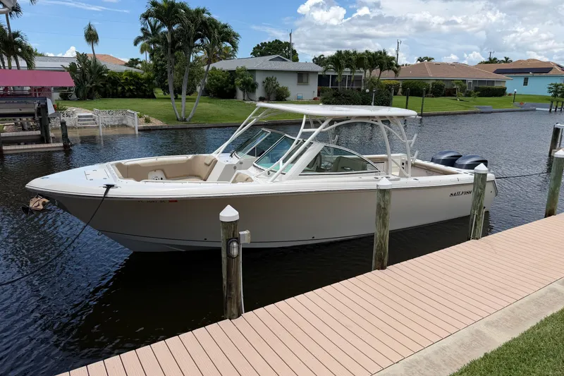 The Image of 2018 Sailfish 325 DC boat docked on a calm canal with palm trees. - 0
