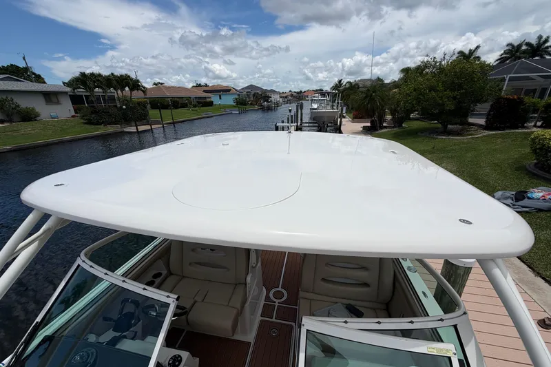 Slide: The Image of 2018 Sailfish 325 DC boat docked by a scenic canal under a cloudy sky. - 13