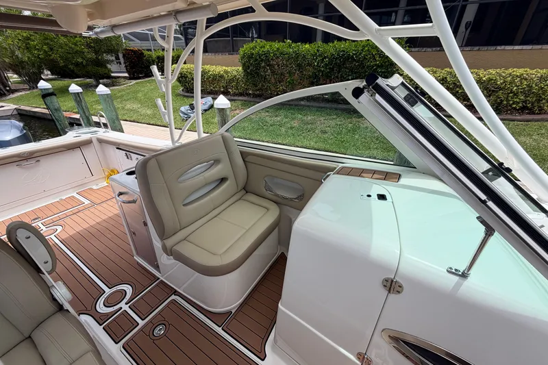 Slide: The Image of 2018 Sailfish 325 DC boat interior with beige seating and wooden deck. - 15