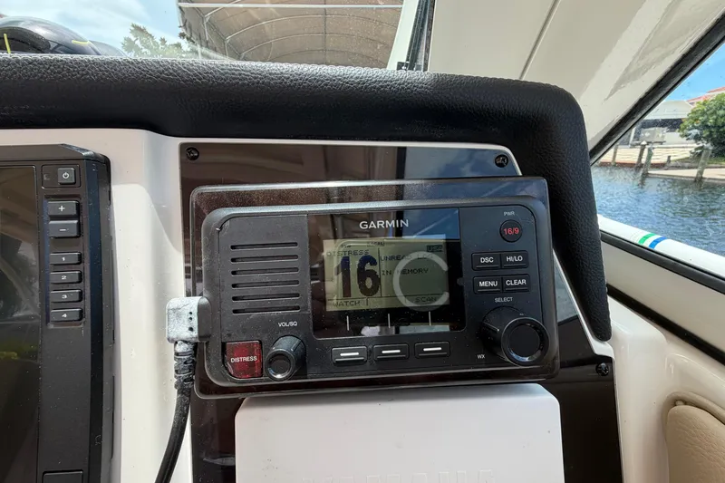 Slide: The Image of Garmin marine radio on 2018 Sailfish 325 DC boat dashboard, near waterway. - 19