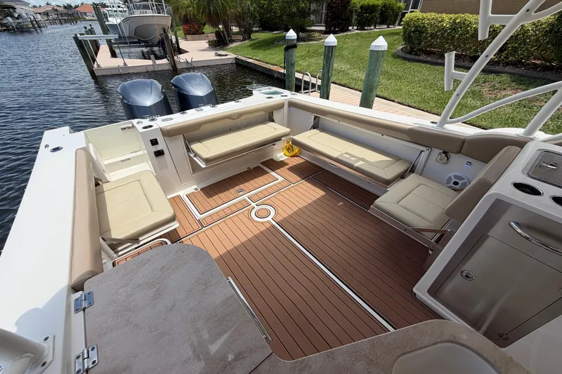 Slide: The Image of 2018 Sailfish 325 DC boat interior with cushioned seating and wooden deck. - 28
