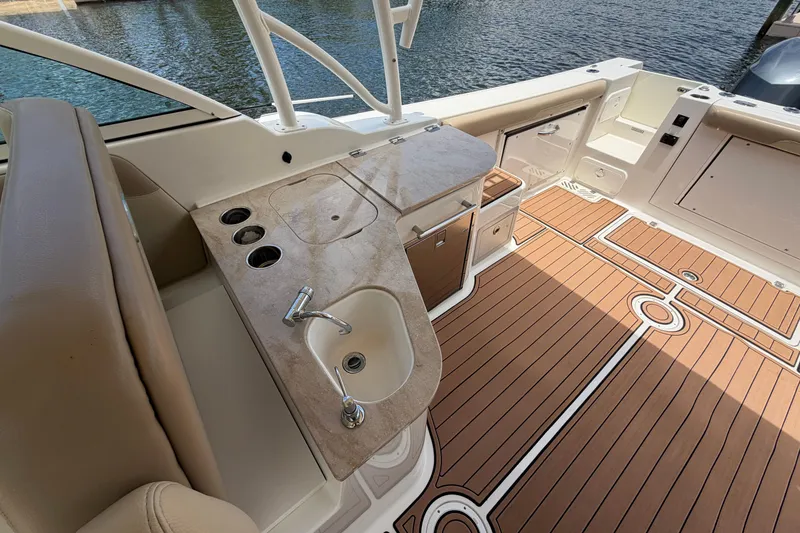 Slide: The Image of 2018 Sailfish 325 DC boat interior with sink, countertop, and teak-style flooring. - 29