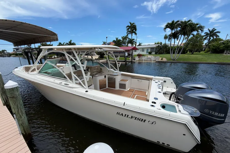 Slide: The Image of 2018 Sailfish 325 DC boat docked by a scenic waterfront with Yamaha engines. - 3