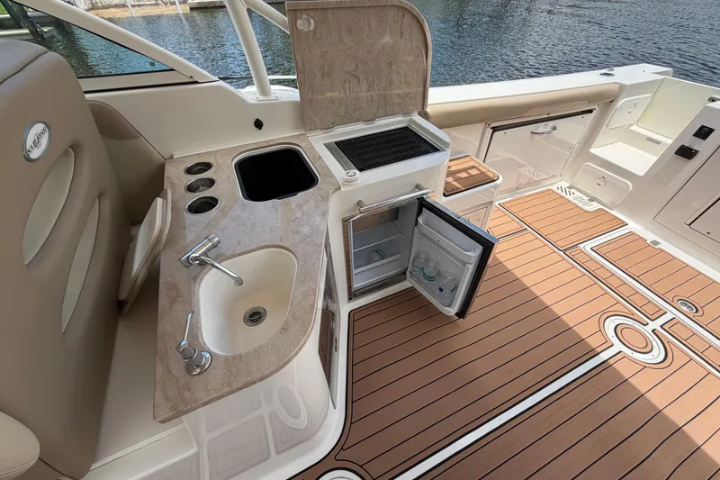 Slide: The Image of 2018 Sailfish 325 DC boat interior with sink, fridge, and teak flooring. - 30