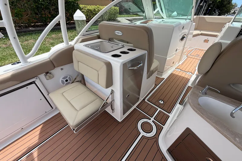Slide: The Image of 2018 Sailfish 325 DC boat interior with seating, sink, and teak flooring. - 32