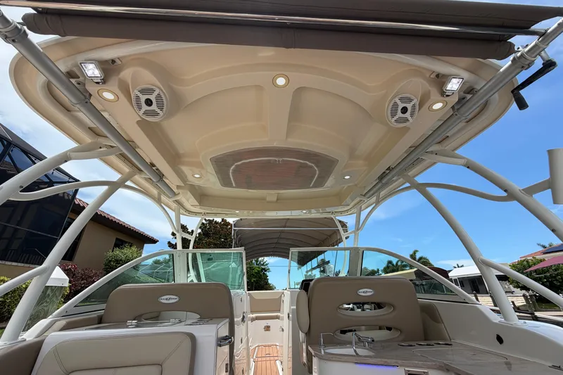 Slide: The Image of 2018 Sailfish 325 DC boat interior with speakers and seating under canopy. - 33