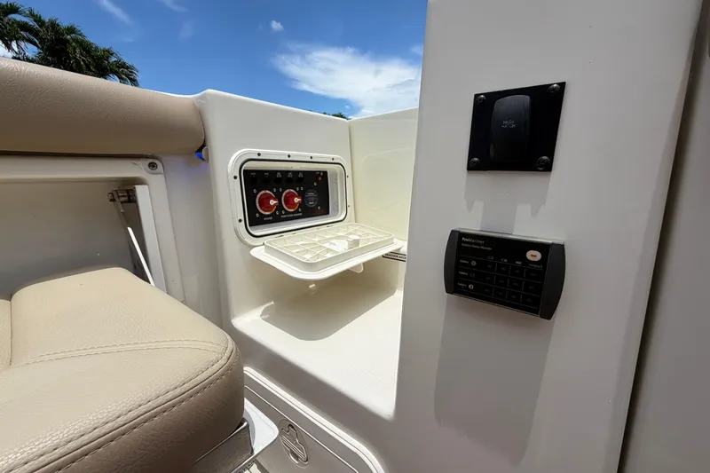 Slide: The Image of 2018 Sailfish 325 DC boat interior with control panel and seating under blue sky. - 35