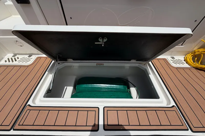 Slide: The Image of Open storage compartment on 2018 Sailfish 325 DC boat deck with teak flooring. - 36