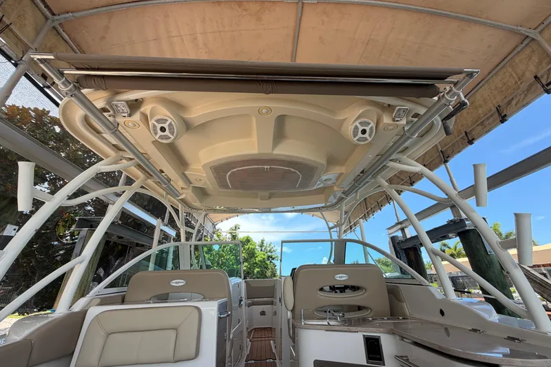 Slide: The Image of 2018 Sailfish 325 DC boat interior with seating and canopy under a dock shelter. - 37