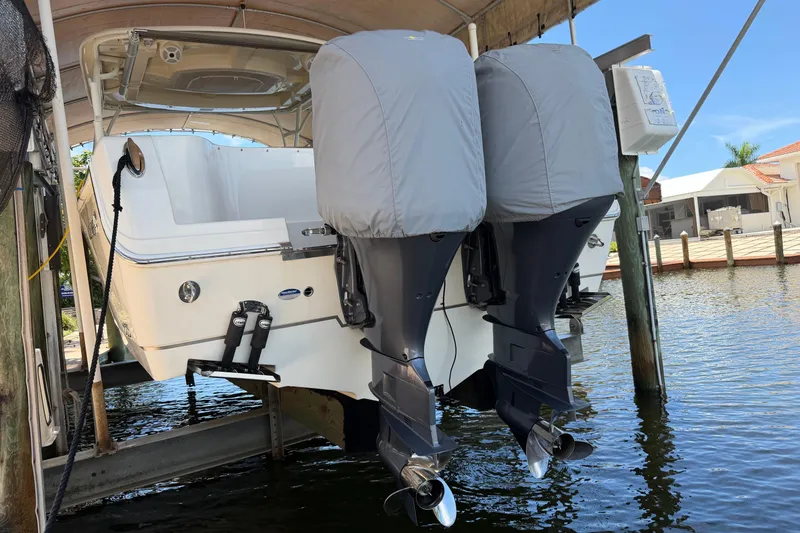 Slide: The Image of 2018 Sailfish 325 DC boat with dual covered outboard motors on a lift. - 38