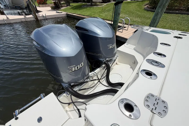 Slide: The Image of Twin Yamaha 300 engines on a 2018 Sailfish 325 DC boat docked by the water. - 7