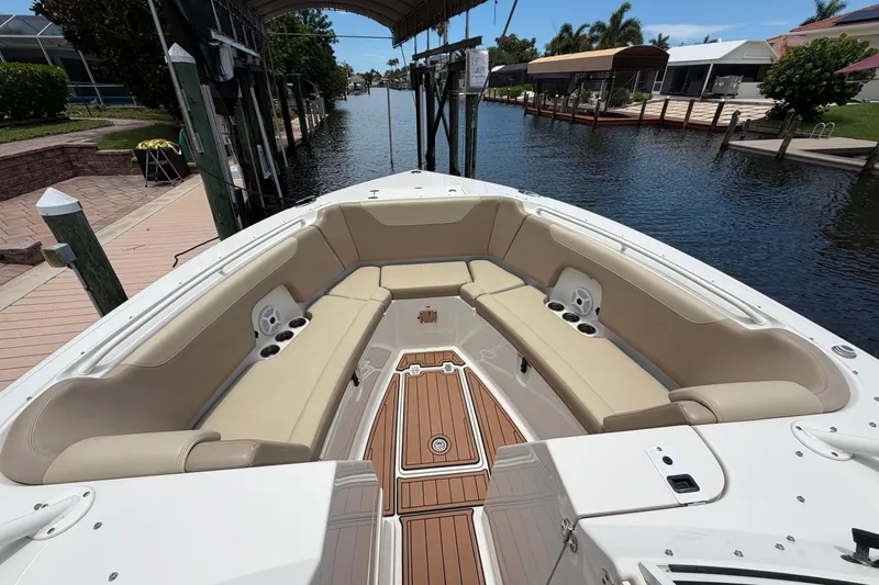 Slide: The Image of 2018 Sailfish 325 DC boat with spacious seating, docked by a serene waterfront. - 9