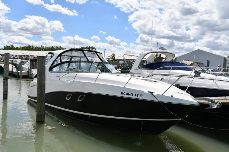 The Image of 2017 Rinker EX 320 boat docked at marina under cloudy sky. - 1