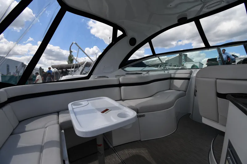 Slide: The Image of Interior of 2017 Rinker EX 320 boat with seating and table under a clear sky. - 10