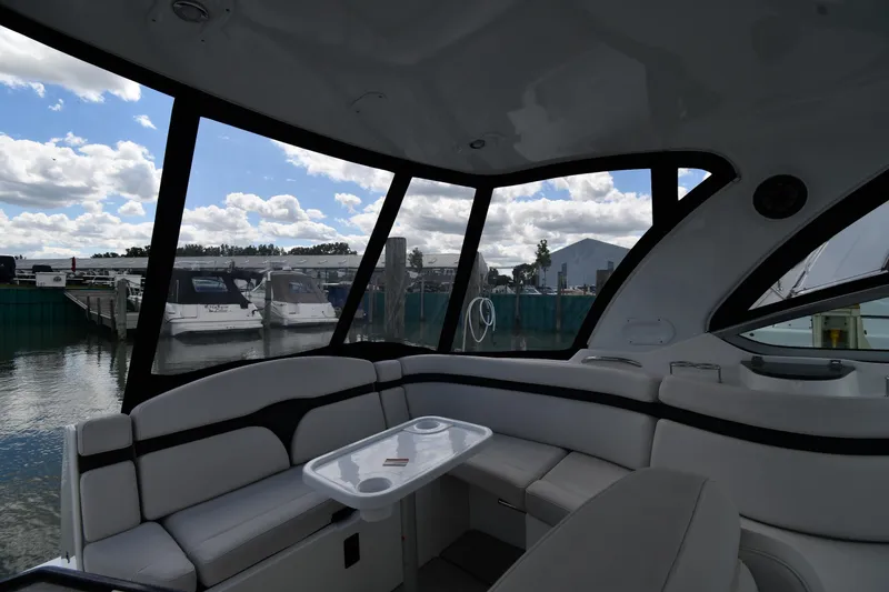 Slide: The Image of Interior view of 2017 Rinker EX 320 boat with marina backdrop. - 11
