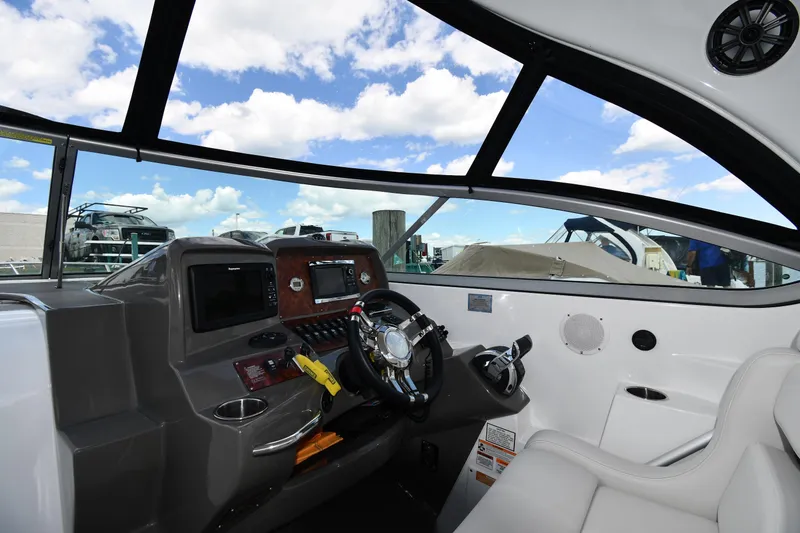 Slide: The Image of Interior view of 2017 Rinker EX 320 boat cockpit with steering wheel and controls. - 13