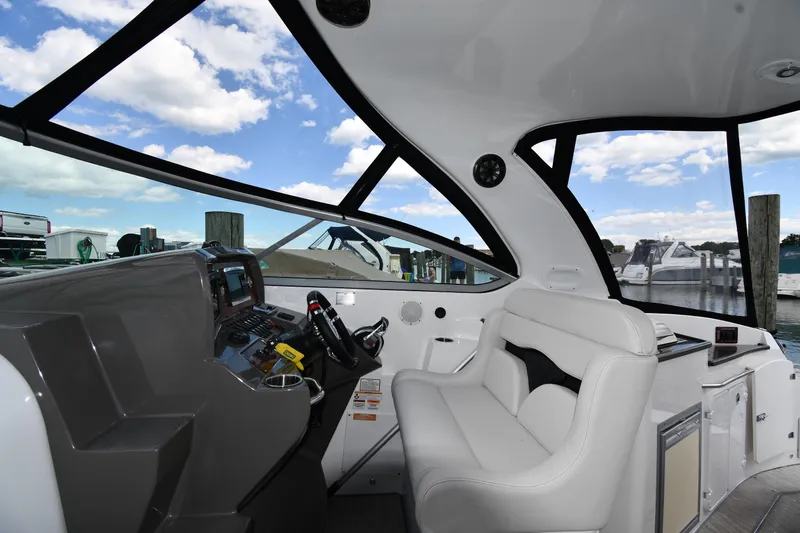 Slide: The Image of Interior view of 2017 Rinker EX 320 boat cockpit with white seating and control panel. - 17