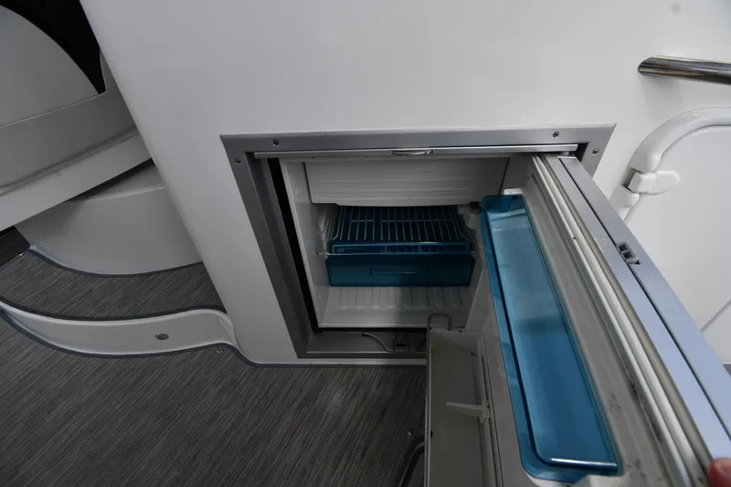 Slide: The Image of Open refrigerator on 2017 Rinker EX 320 boat, showcasing interior storage space. - 19