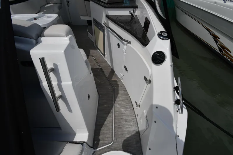 Slide: The Image of 2017 Rinker EX 320 boat interior with seating and kitchenette area. - 20