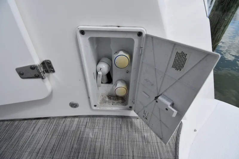 Slide: The Image of 2017 Rinker EX 320 boat compartment with open hatch and controls. - 21