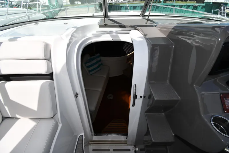 Slide: The Image of 2017 Rinker EX 320 boat interior with cabin entrance and seating area. - 24