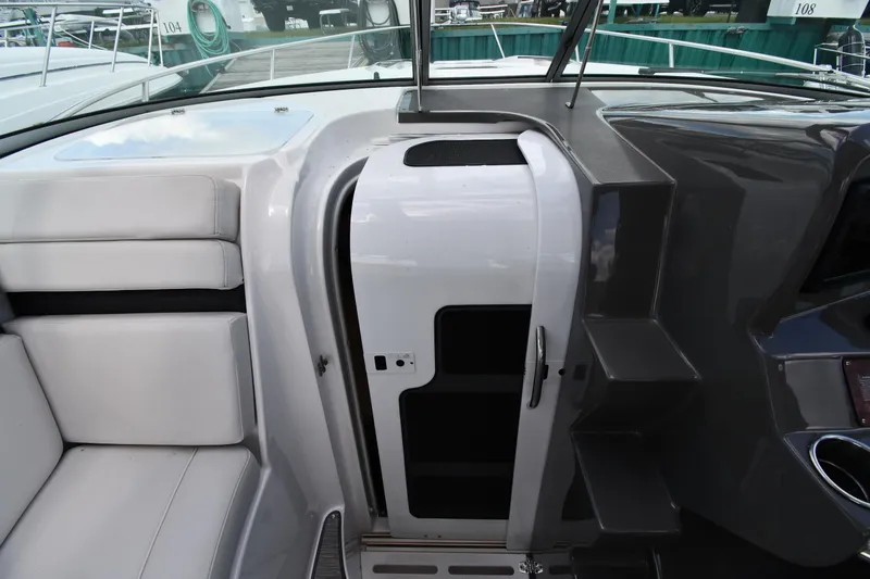 Slide: The Image of 2017 Rinker EX 320 boat interior with seating and cabin entrance. - 25