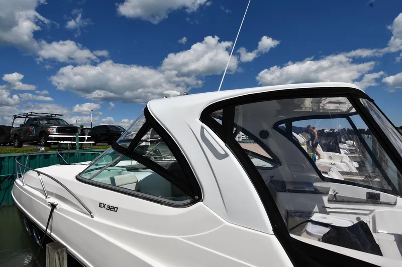 Slide: The Image of 2017 Rinker EX 320 boat docked under a bright blue sky with clouds. - 3