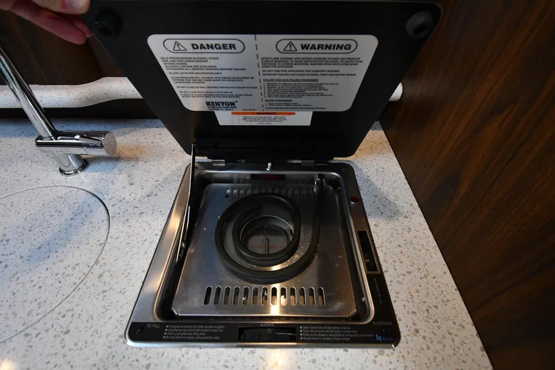 Slide: The Image of 2017 Rinker EX 320 boat stove with safety warnings and sleek countertop design. - 32
