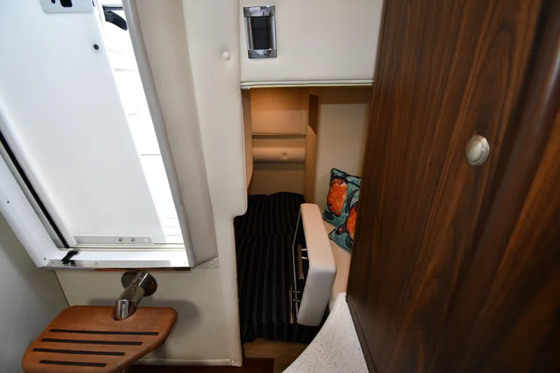 Slide: The Image of 2017 Rinker EX 320 cabin interior with cozy bed and decorative pillows. - 35