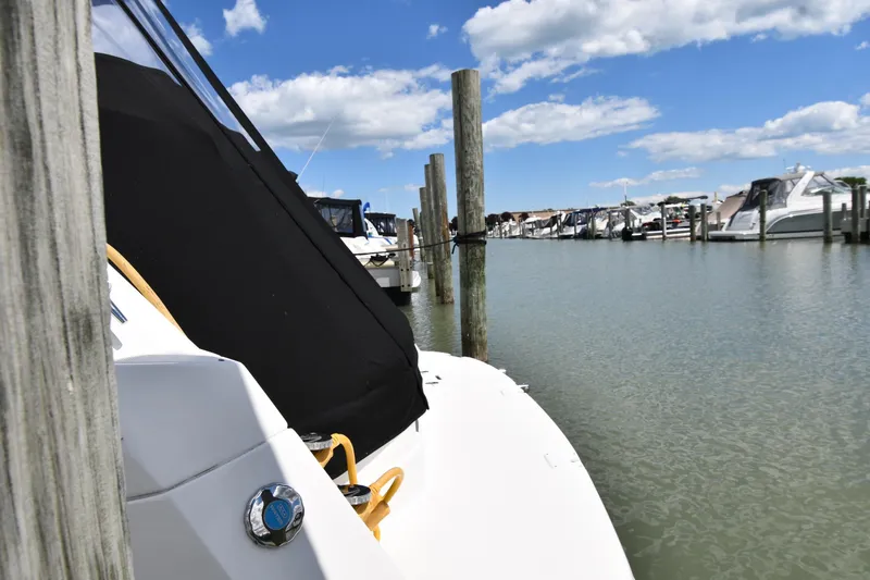Slide: The Image of 2017 Rinker EX 320 boat docked at marina under blue sky. - 4