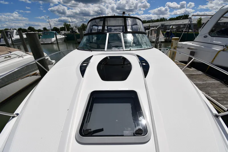 Slide: The Image of 2017 Rinker EX 320 boat docked at marina under cloudy sky. - 7