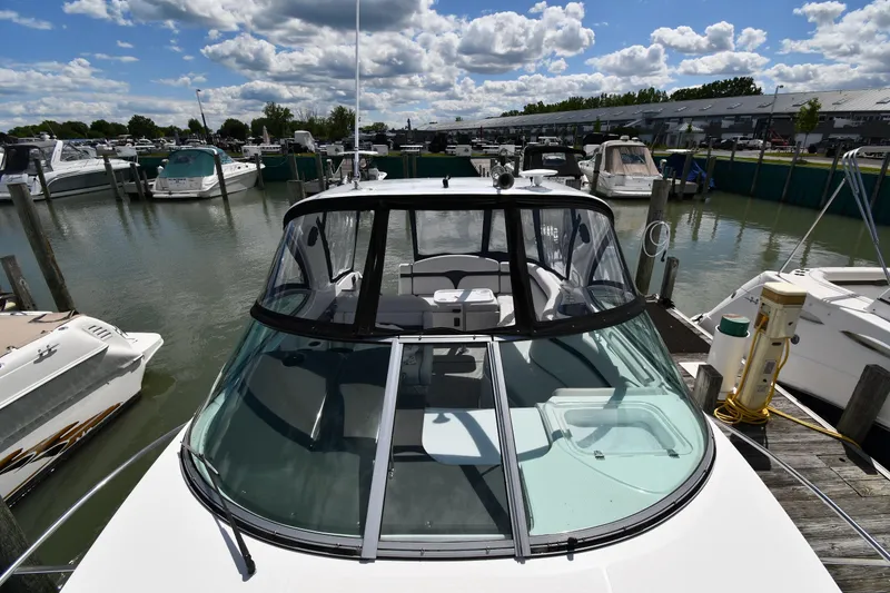 Slide: The Image of 2017 Rinker EX 320 boat docked at marina under cloudy sky. - 8