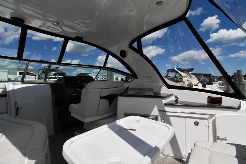 Slide: The Image of Interior of 2017 Rinker EX 320 boat with white seating and clear windows. - 9