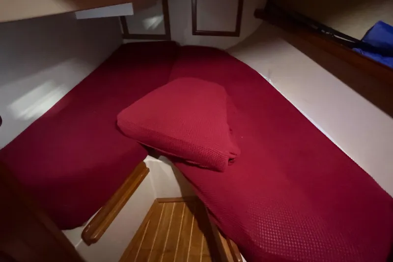 Slide: The Image of Interior cabin of 1990 Island Packet 38 sailboat with red bedding. - 11
