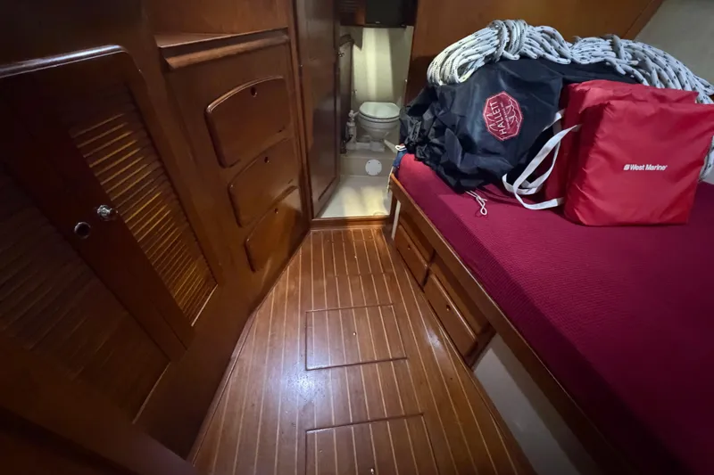 Slide: The Image of Interior of 1990 Island Packet 38 sailboat with wooden flooring and storage. - 15