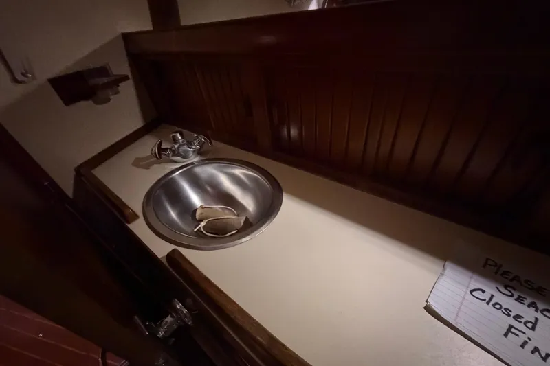Slide: The Image of 1990 Island Packet 38 yacht interior with stainless steel sink and wooden cabinetry. - 19