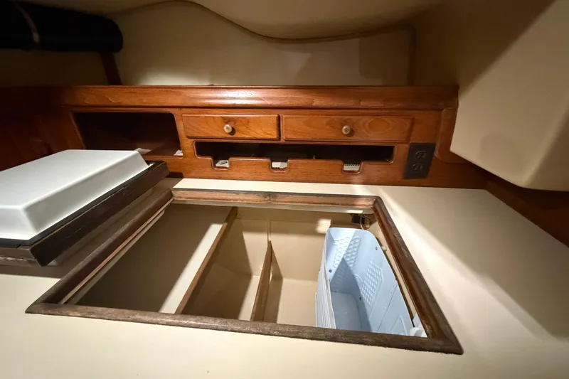 Slide: The Image of Interior view of a 1990 Island Packet 38 sailboat, featuring wooden cabinetry and storage compartments. - 22