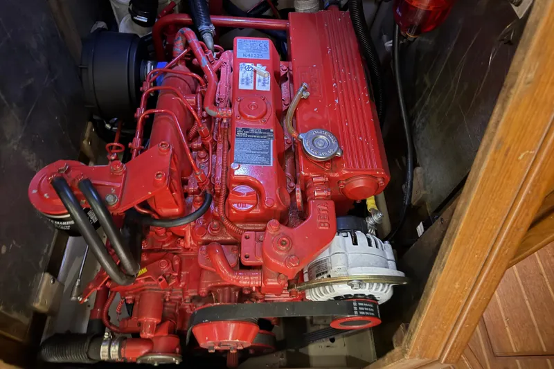 Slide: The Image of Red engine inside a 1990 Island Packet 38 sailboat, showcasing detailed mechanical components. - 28