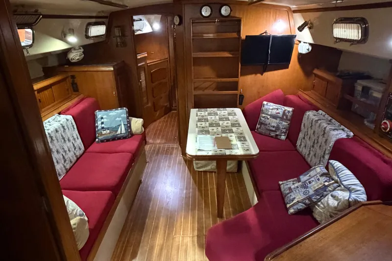 Slide: The Image of Interior of a 1990 Island Packet 38 sailboat with red seating and nautical decor. - 3