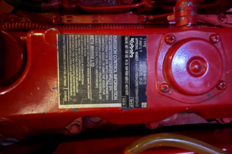 Slide: The Image of Red engine component with emission control label, Island Packet 38, 1990 model. - 31