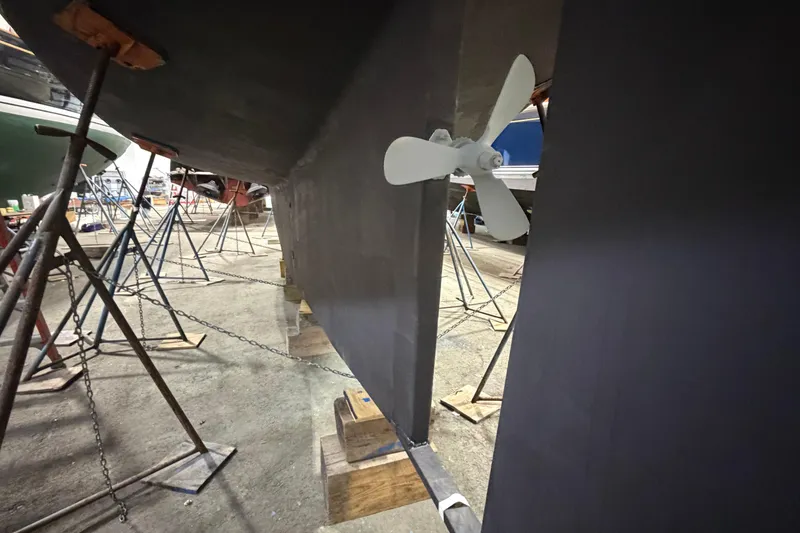 Slide: The Image of 1990 Island Packet 38 sailboat in dry dock, showcasing propeller and keel. - 33