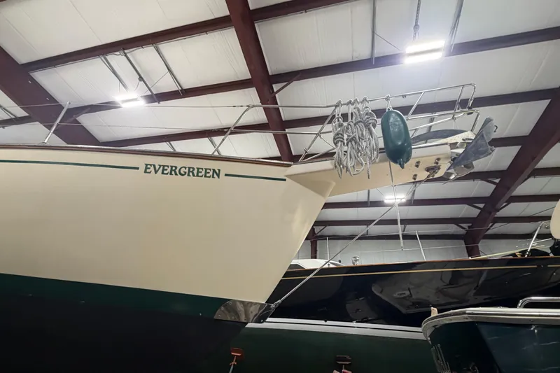 Slide: The Image of 1990 Island Packet 38 sailboat "Evergreen" in indoor storage, showcasing bow and rigging. - 35