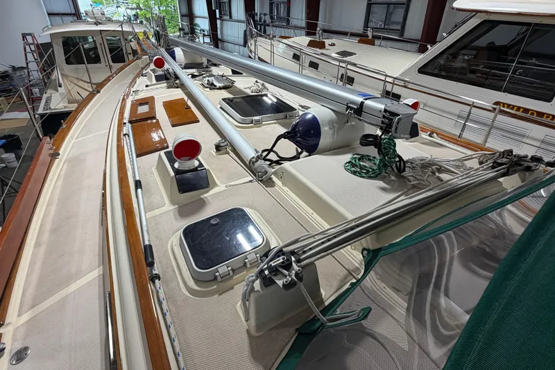 Slide: The Image of 1990 Island Packet 38 sailboat deck with rigging and hatches in a marina setting. - 38