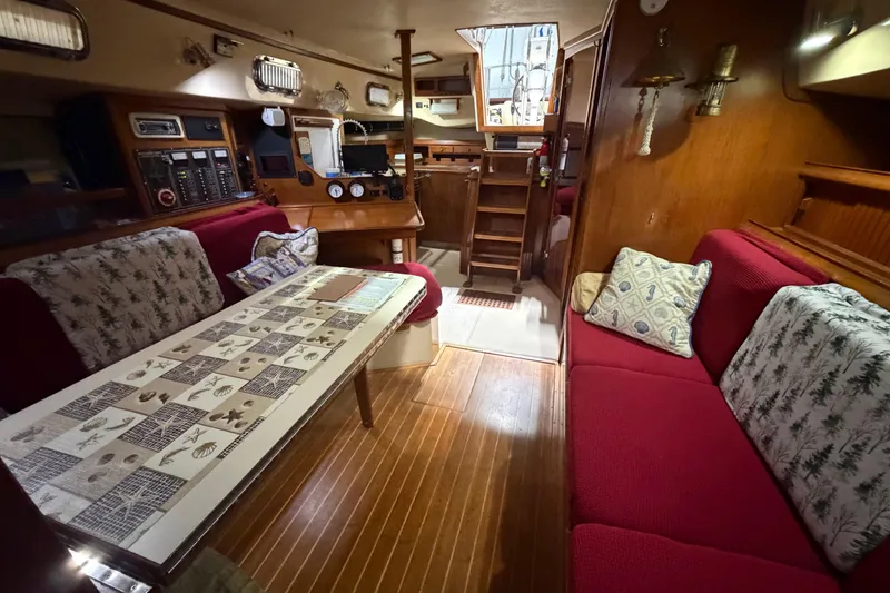 Slide: The Image of Interior of a 1990 Island Packet 38 sailboat with cozy seating and nautical decor. - 4