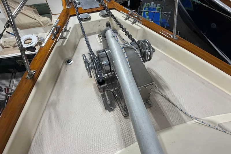 Slide: The Image of Anchor windlass on 1990 Island Packet 38 sailboat deck, featuring chains and wooden trim. - 40