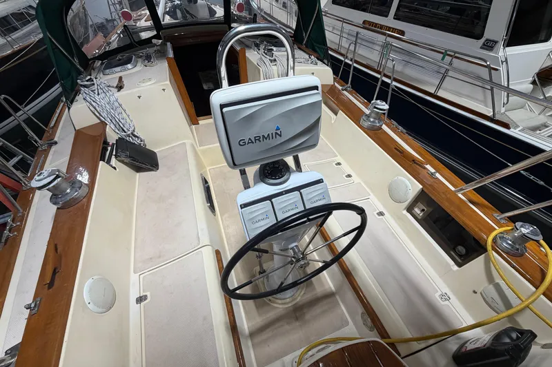 Slide: The Image of 1990 Island Packet 38 sailboat cockpit with Garmin navigation system and wooden trim. - 47