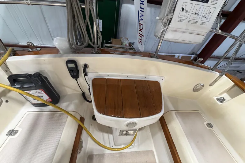 Slide: The Image of Interior view of a 1990 Island Packet 38 sailboat cockpit with wooden seat and equipment. - 52