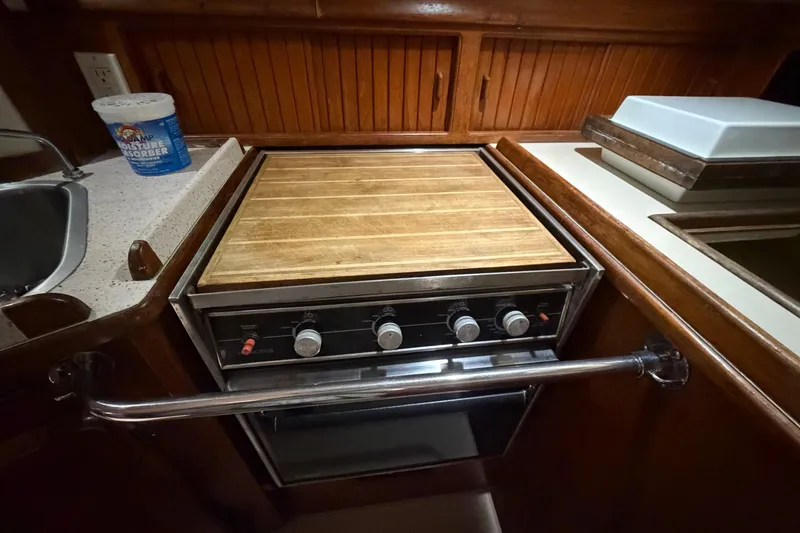 Slide: The Image of 1990 Island Packet 38 yacht kitchen with stove and wooden countertop. - 9