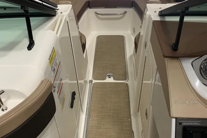 Slide: The Image of Interior view of a Sea Ray 240 Sundeck boat with beige flooring and brown seating. - 21